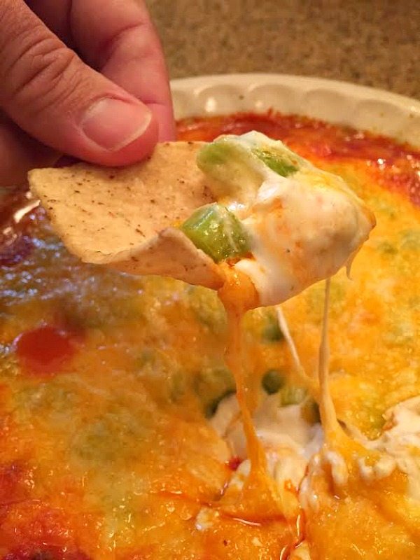 hand holding chip dipped into buffalo chicken dip