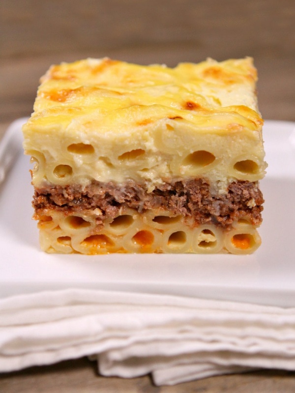 Slice of Pastitsio on a white plate with a white napkin