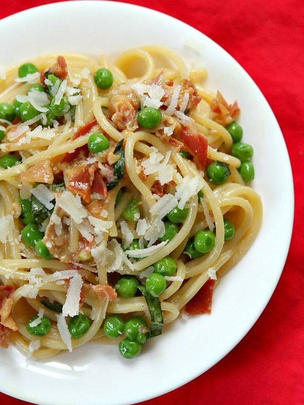 overhead shot of spaghetti carbonara on a white plate set on a red napkin