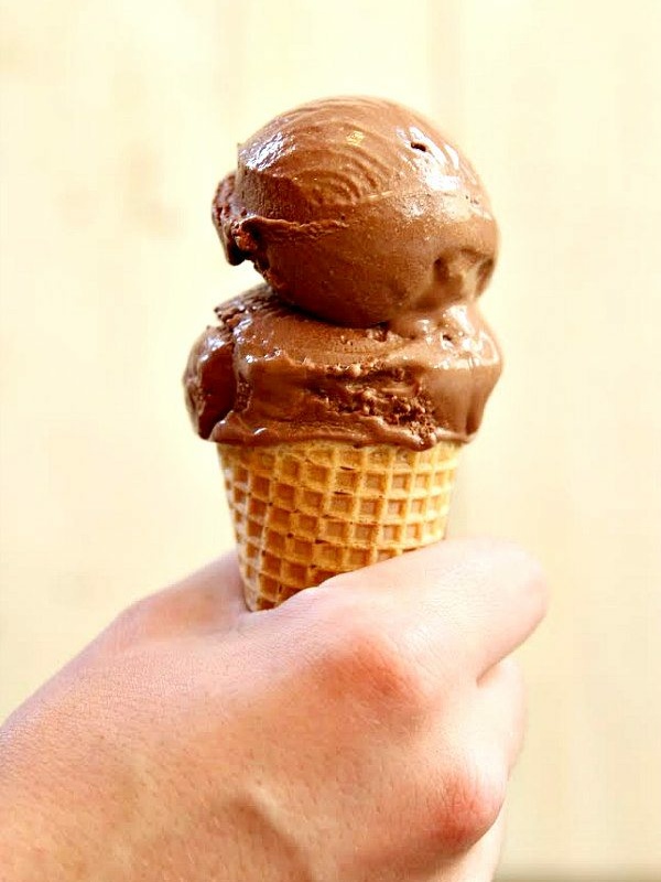 hand holding ice cream cone with two scoops of chocolate espresso gelato