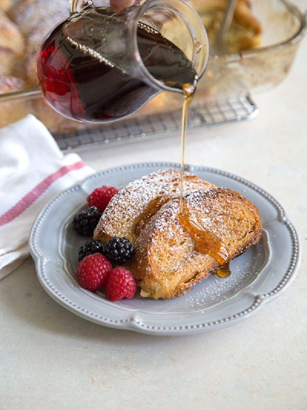 pouring syrup onto eggnog french toast casserole