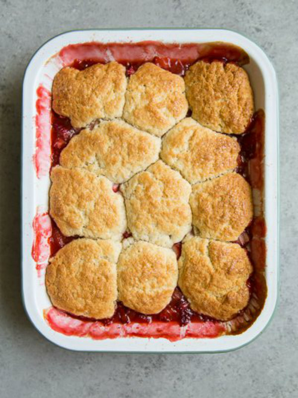 overhead shot of strawberry rhubarb cobbler in a white casserole dish