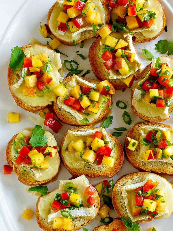 overhead shot of peach and brie bruschetta on a white serving platter