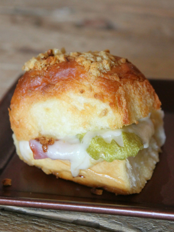 Baked Cuban Slider sitting on a copper metal tray