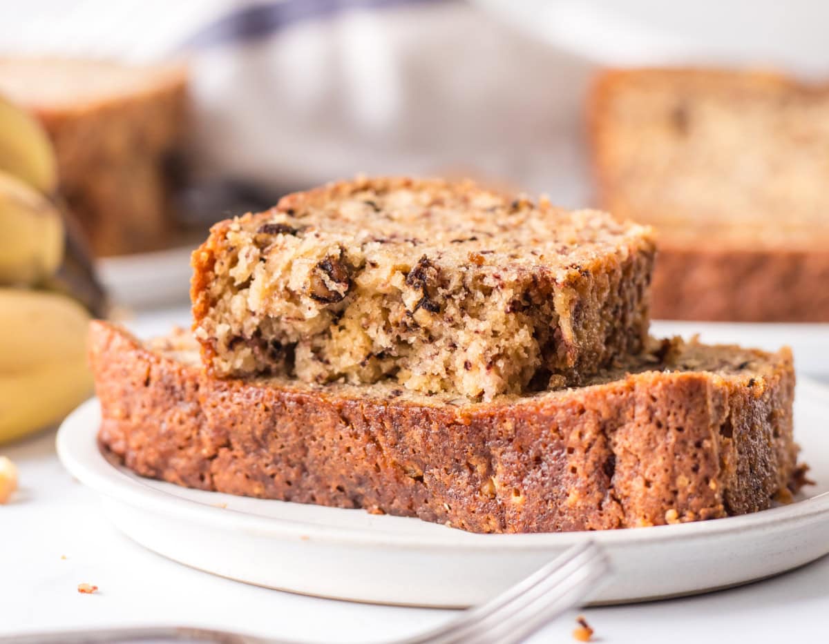 two slices of 2 banana bread on plate with top slice broken open