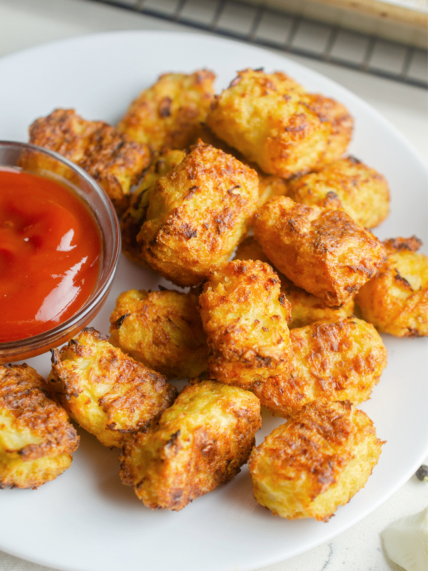 cauliflower tots on white plate served with ketchup