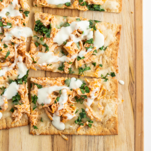 sliced buffalo chicken flatbread on cutting board