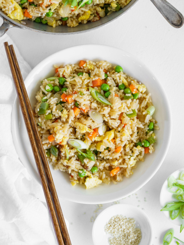 vegetable fried rice in a white bowl with chopsticks