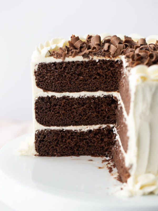 chocolate wedding cake with white frosting and chocolate shavings on top cut into to see inside