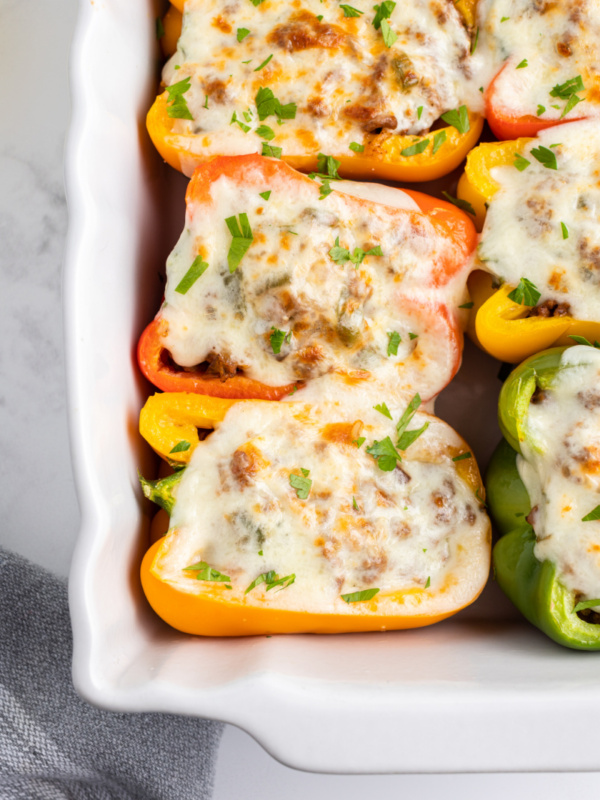 philly cheesesteak stuffed peppers in a white casserole dish