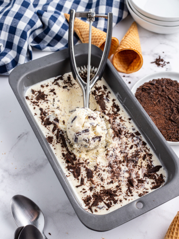 tub of stracciatella gelato with ice cream scoop of it inside