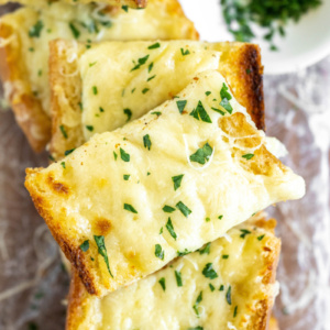 slices of cheesy garlic bread stacked on plate