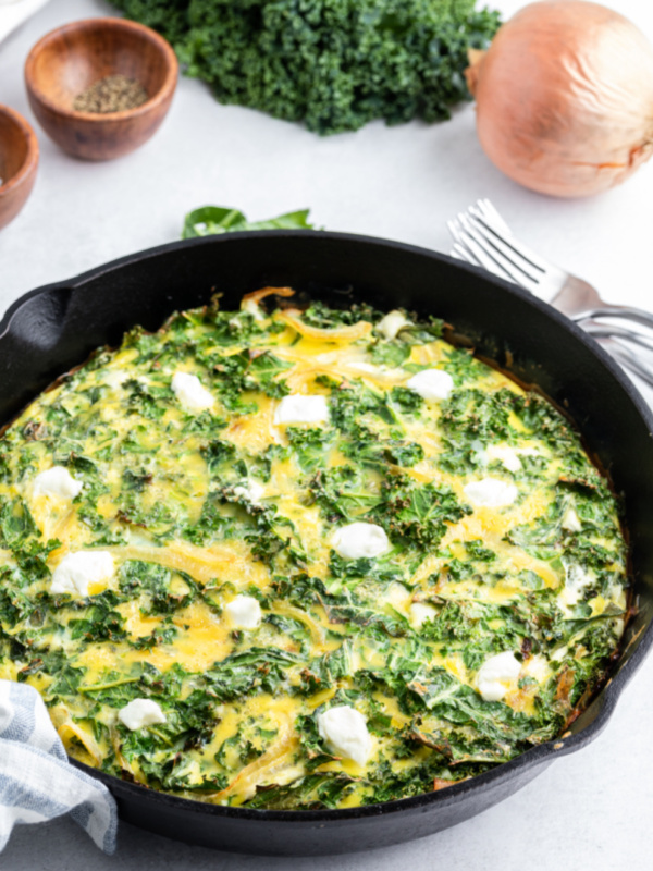 kale and goat cheese frittata in a black skillet