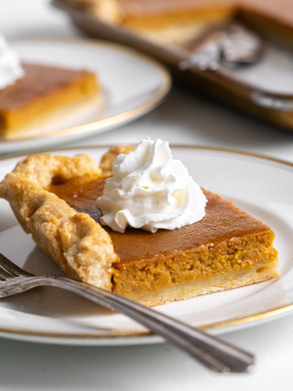 slice of pumpkin slab pie on plate with whipped cream