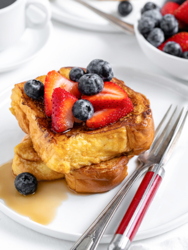 french toast topped with berries and syrup