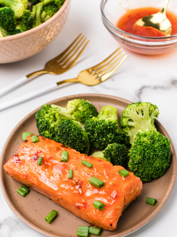 sweet and spicy air fryer salmon on a plate with broccoli