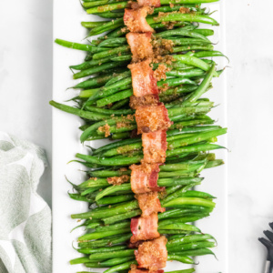 bacon wrapped green beans on a white platter