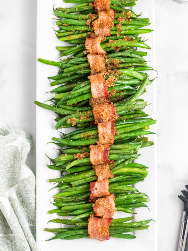 bacon wrapped green beans on a white platter