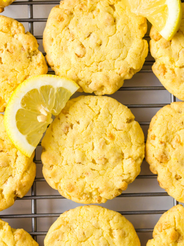 lemon cake mix cookies on a cooling rack with fresh lemon wedges