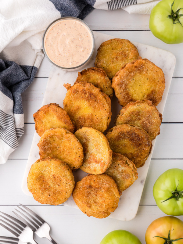 fried green tomatoes on a platter with jar of remoulade sauce