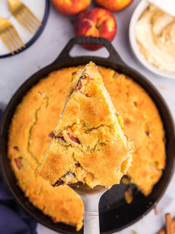 slice of peach cornbread above cast iron cornbread