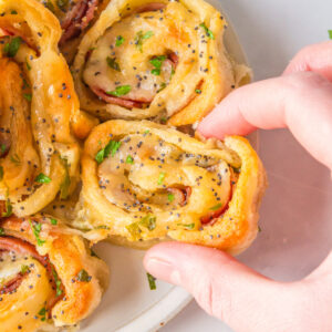 hand holding ham and cheese pinwheels