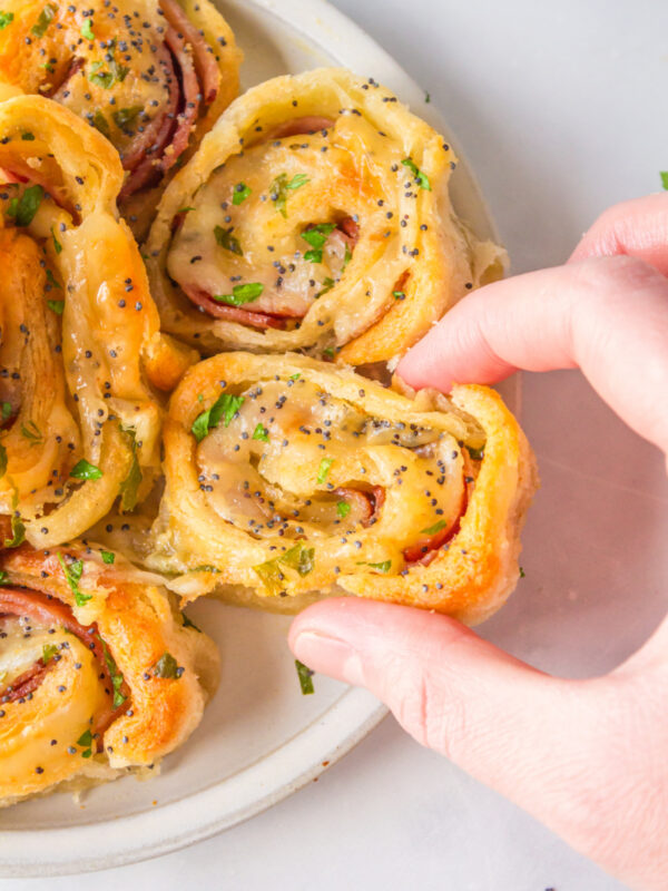 hand holding ham and cheese pinwheels