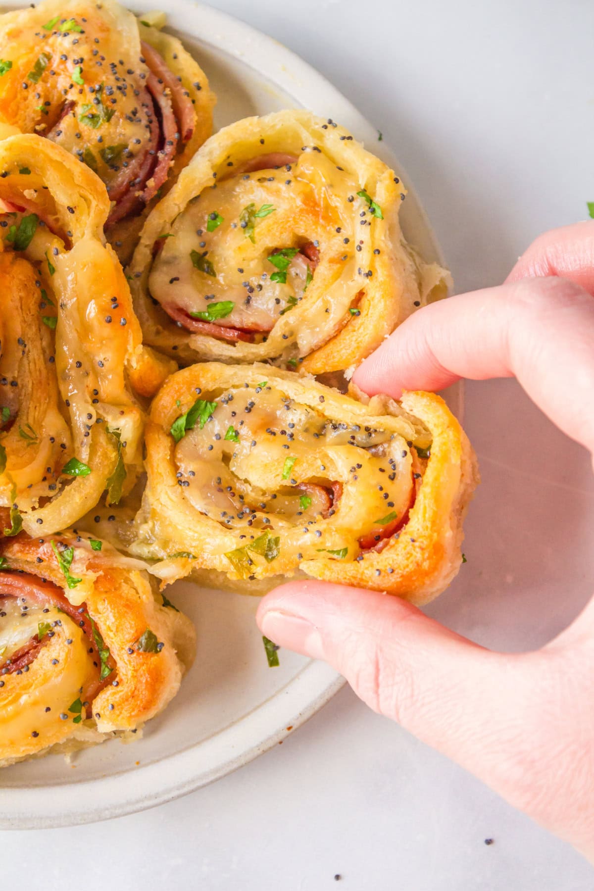 hand holding ham and cheese pinwheels