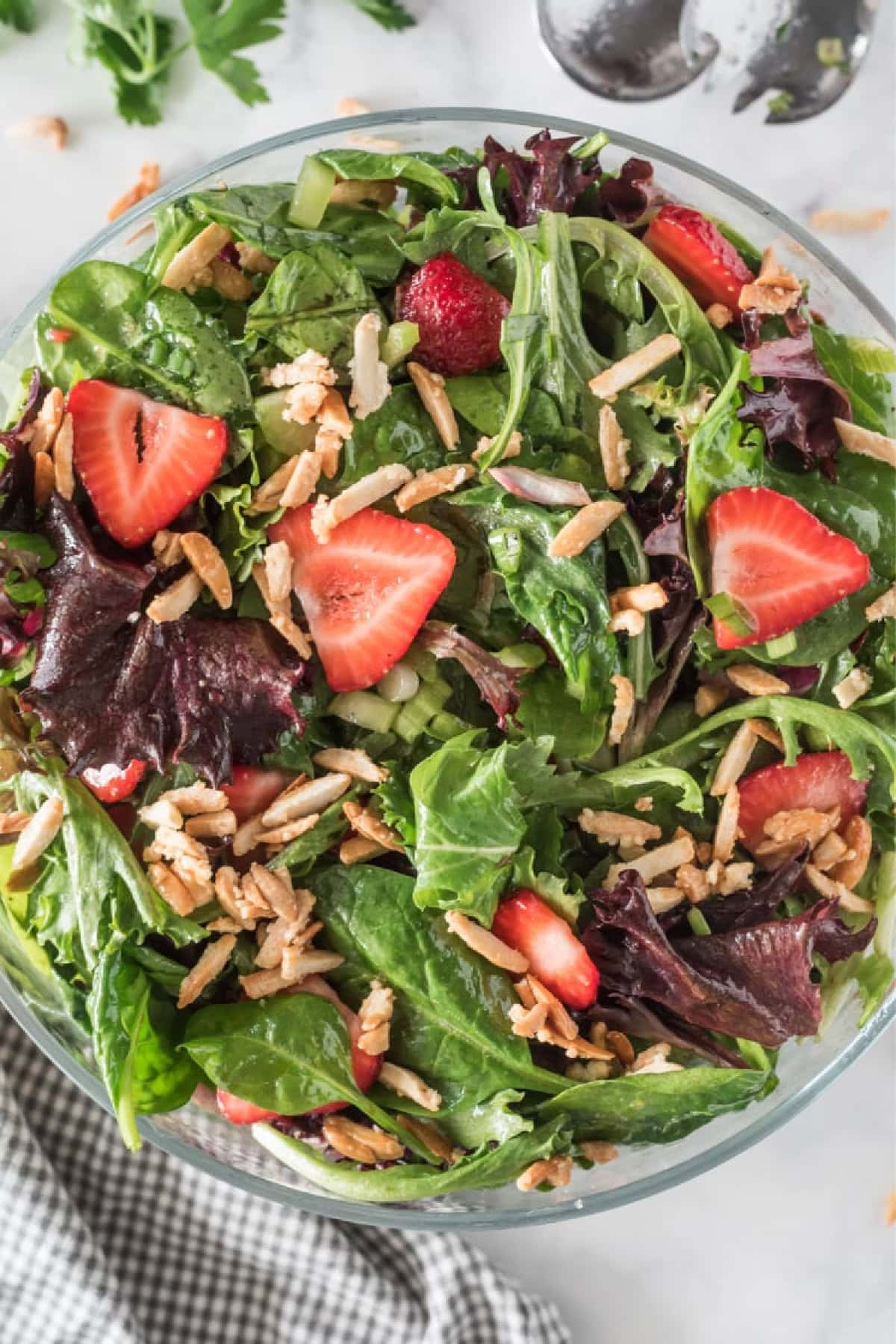 bowl of baby greens with strawberries and sugared almonds