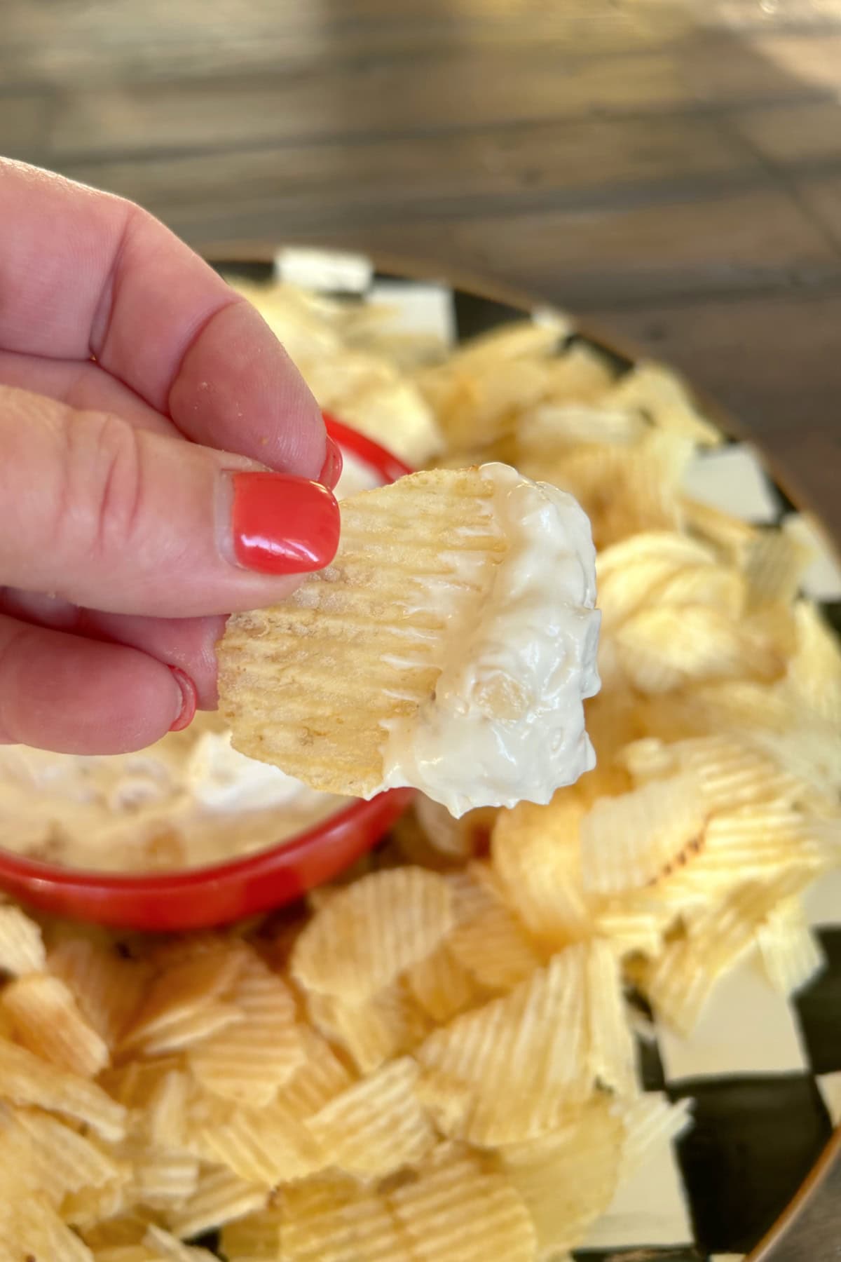 hand holding chip dipped in onion dip