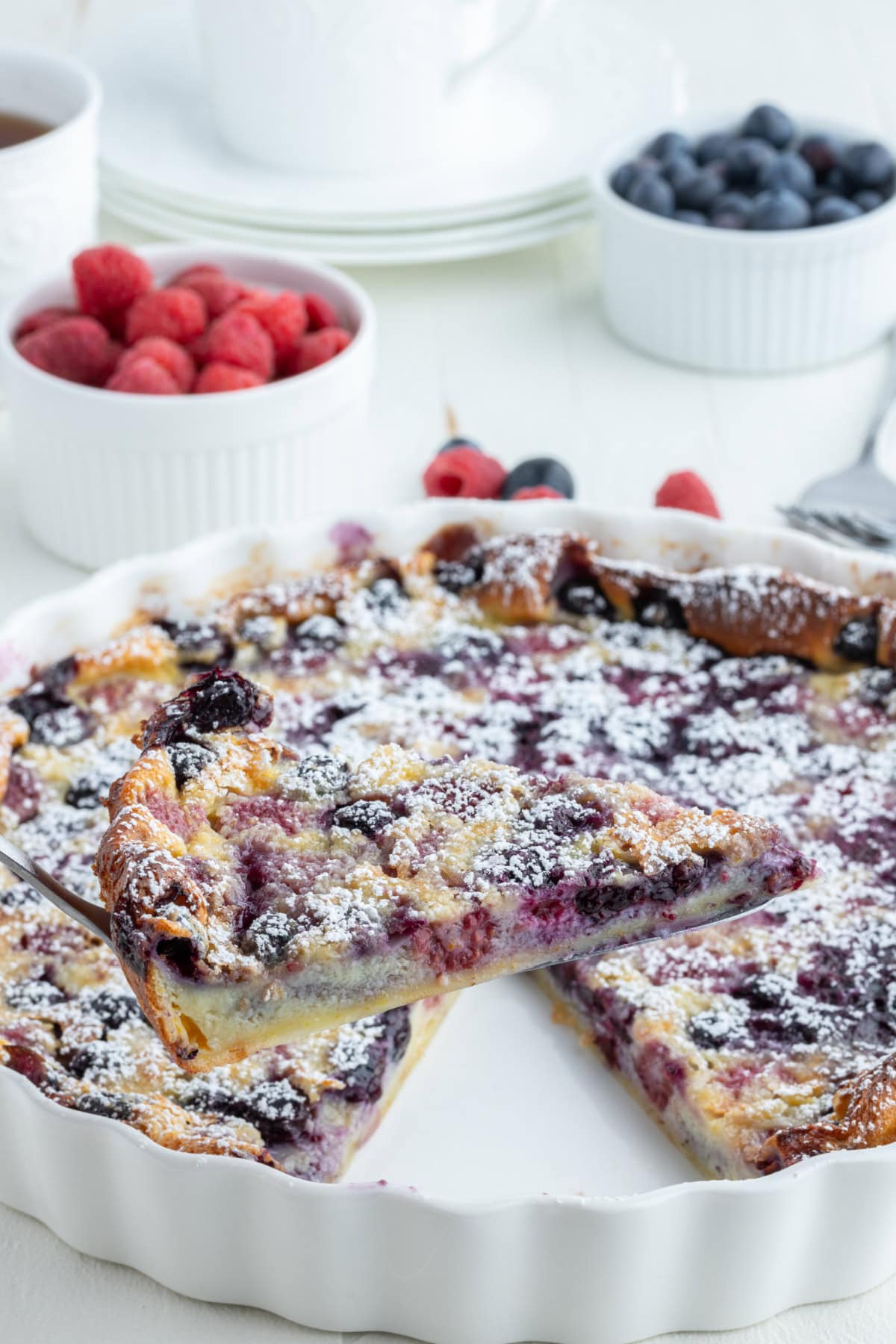 spatula holding up slice of berry clafoutis