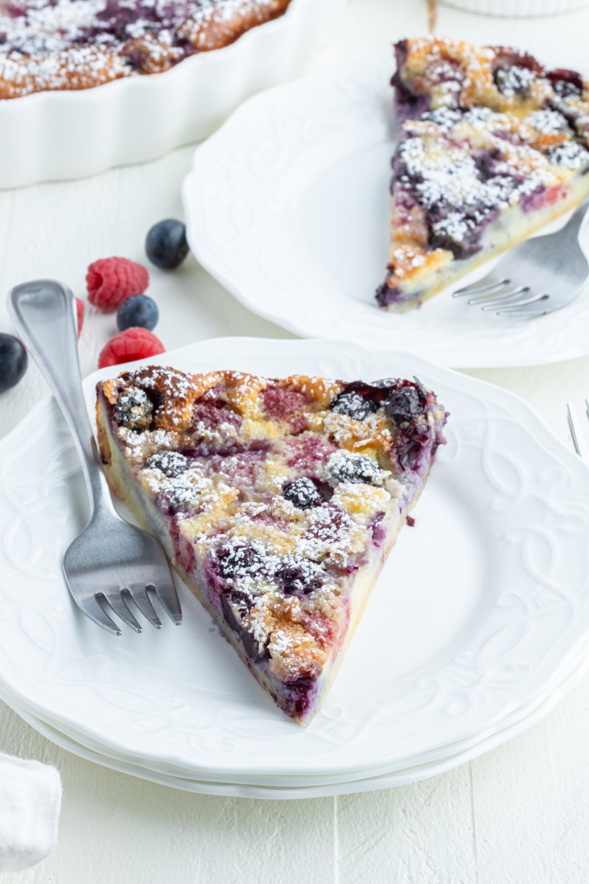 slice of berry clafoutis on plate with fork