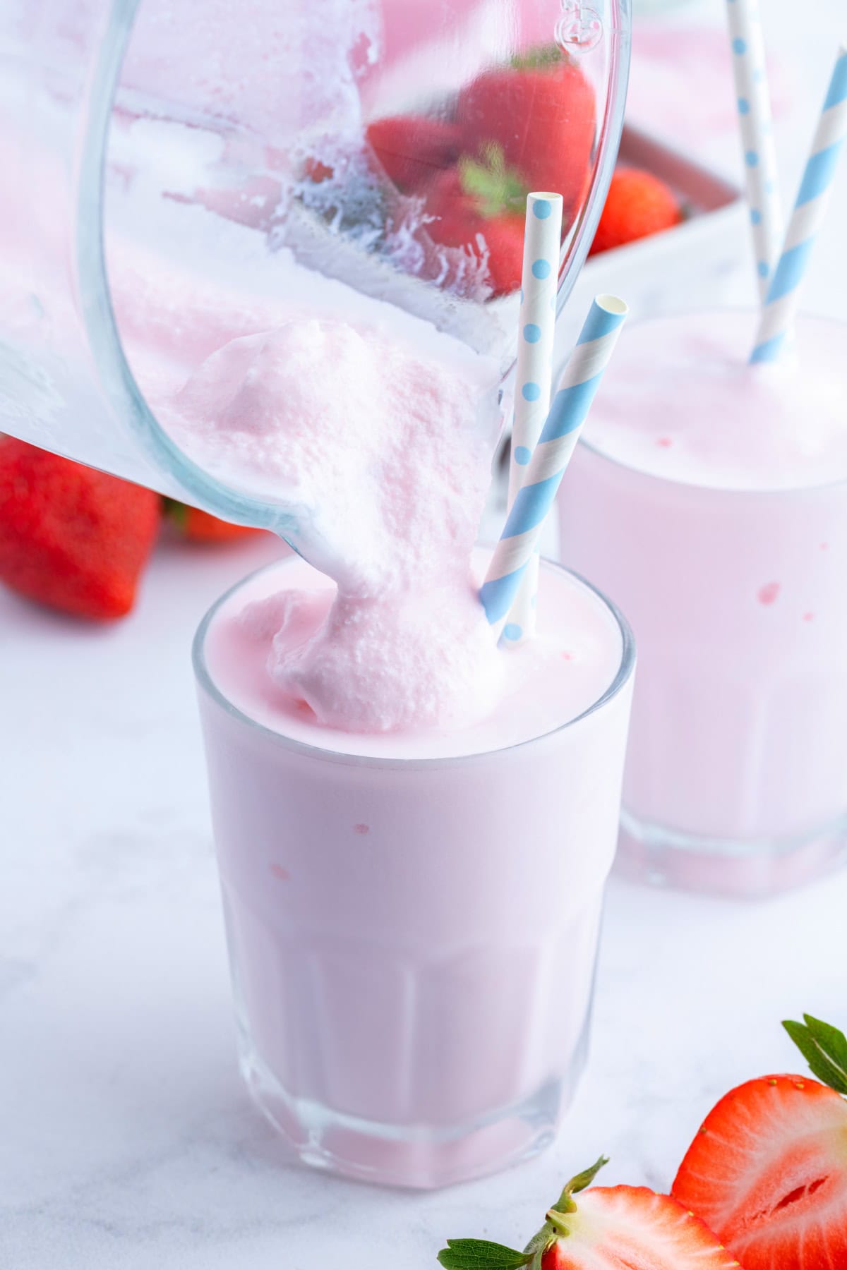 pouring strawberry frosty into glass with straw