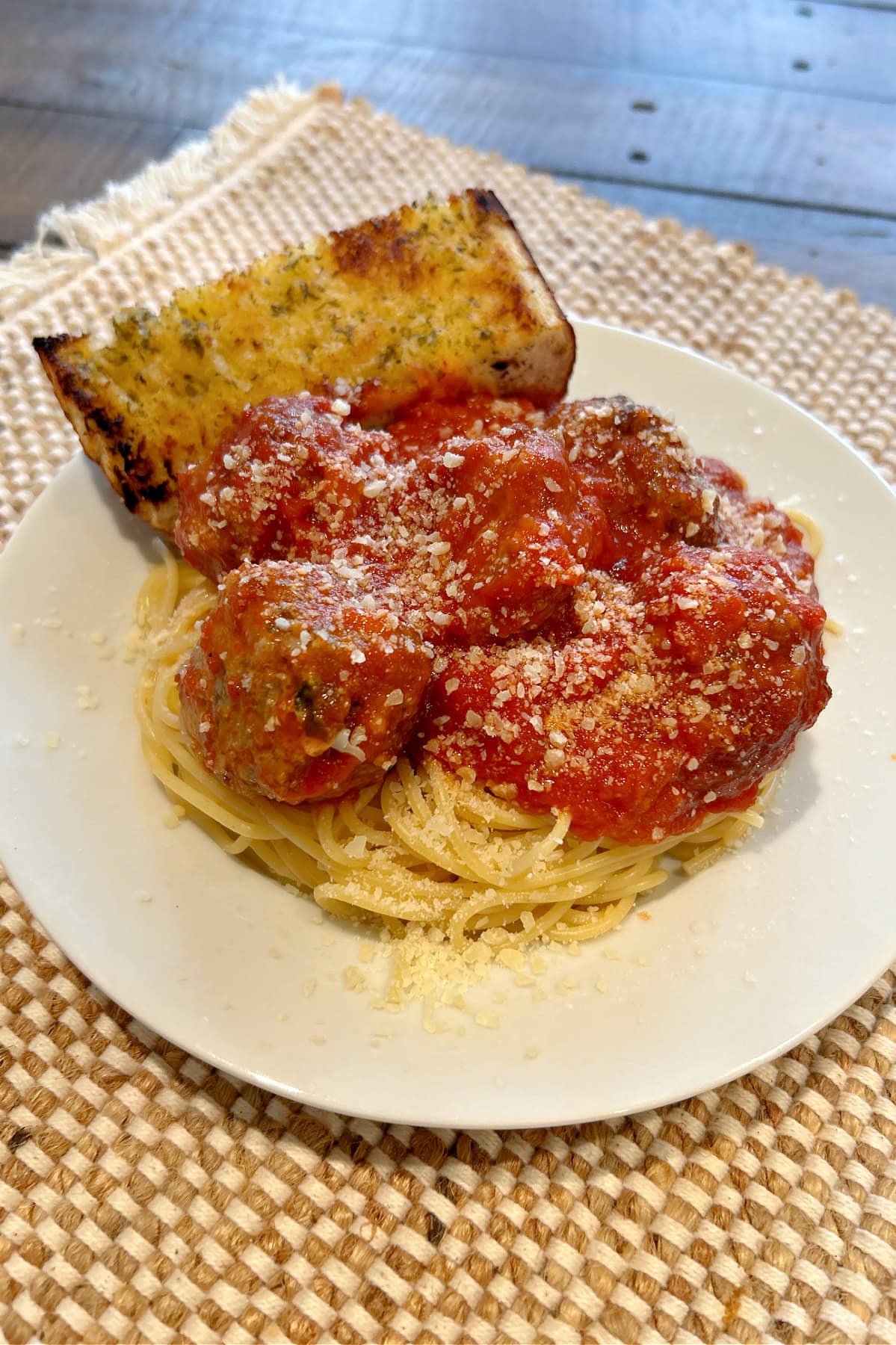 garlic bread meatballs in sauce on pasta on plate with garlic bread