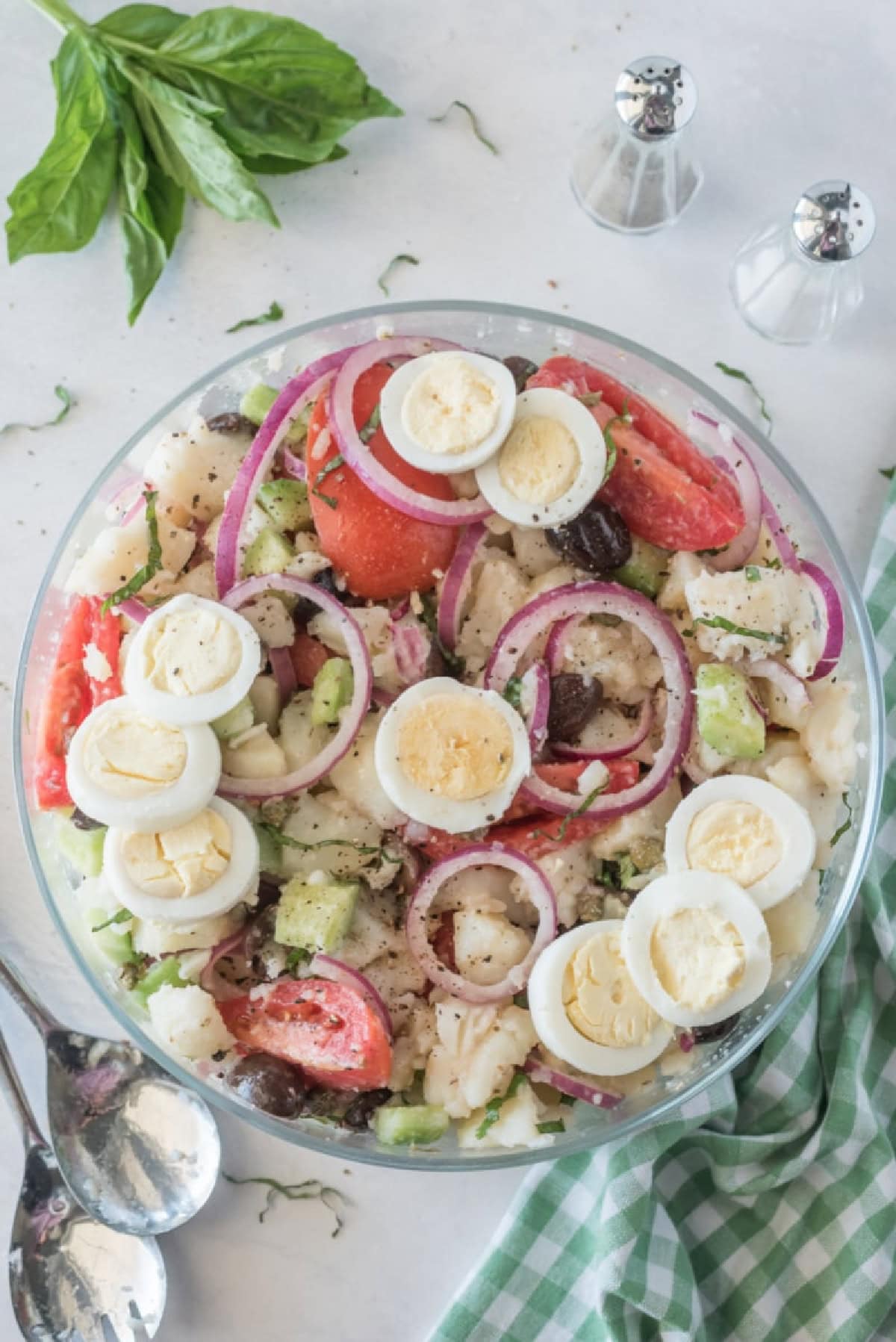 bowl of potato salad with olives tomatoes and capers