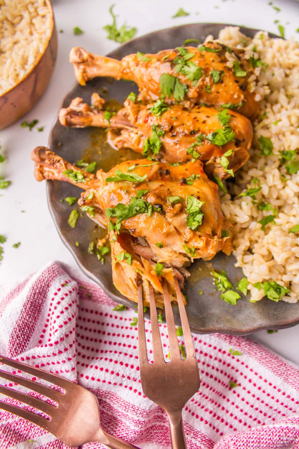 fork tearing open chicken drumstick on plate