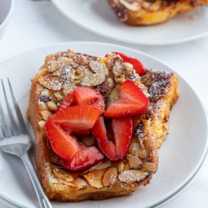 serving of pain perdu on plate topped with strawberries