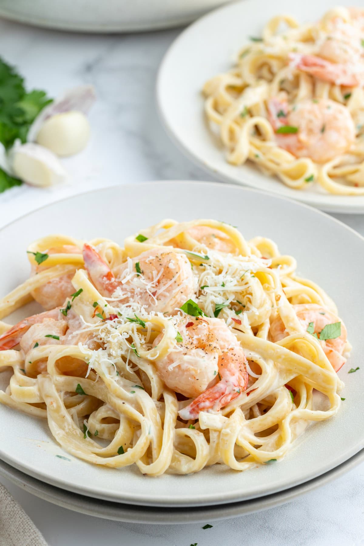 serving of shrimp scampi alfredo on plate with parmesan on top