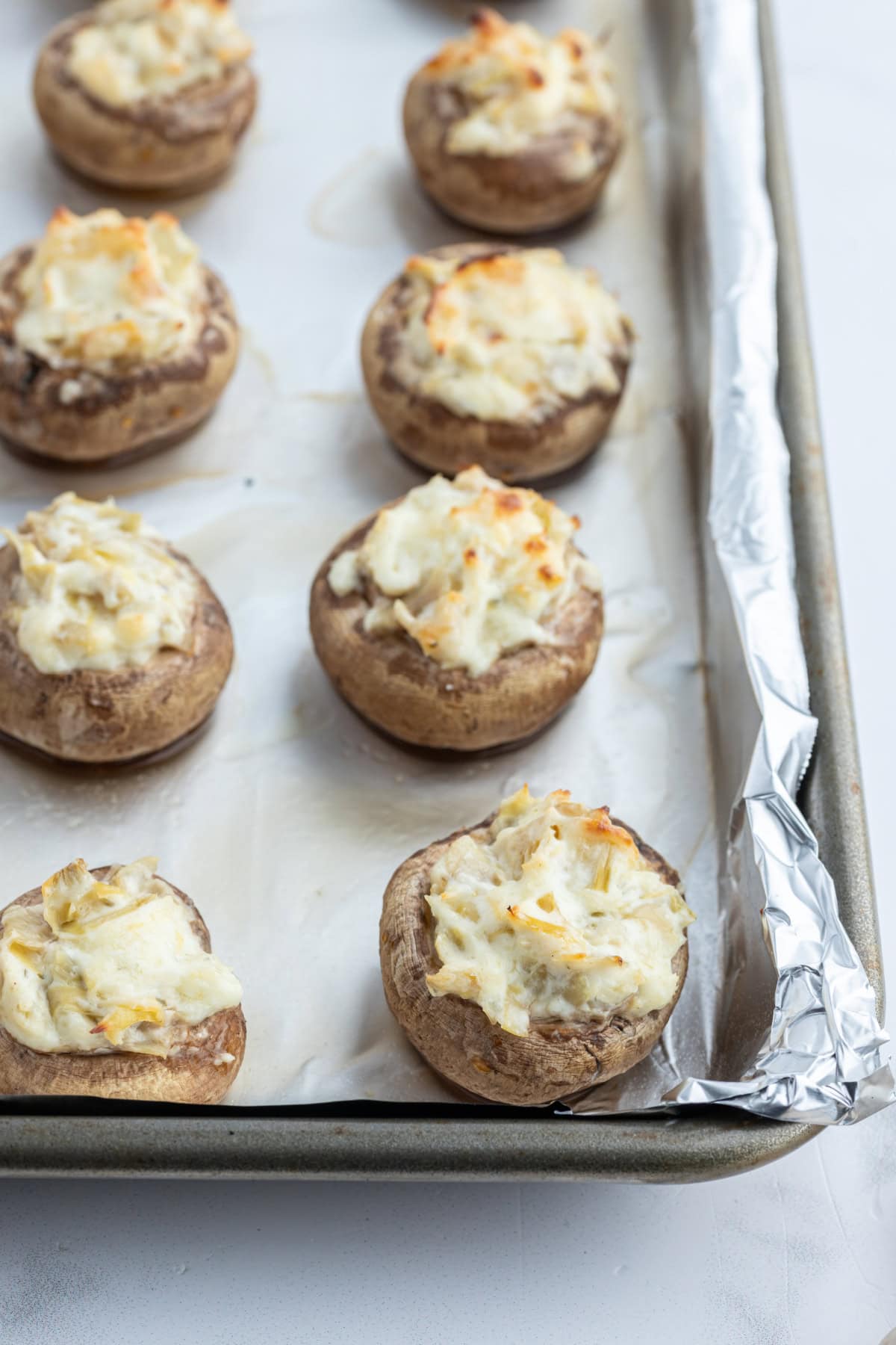 artichoke stuffed mushrooms on baking sheet