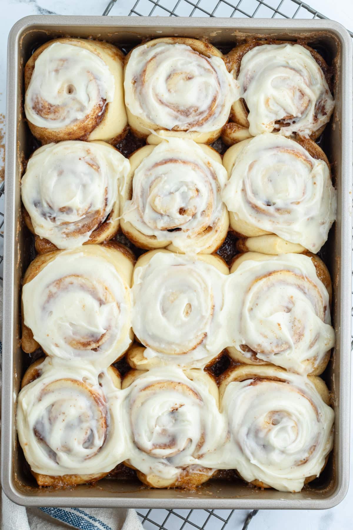 copycat cinnabon cinnamon rolls in pan with icing