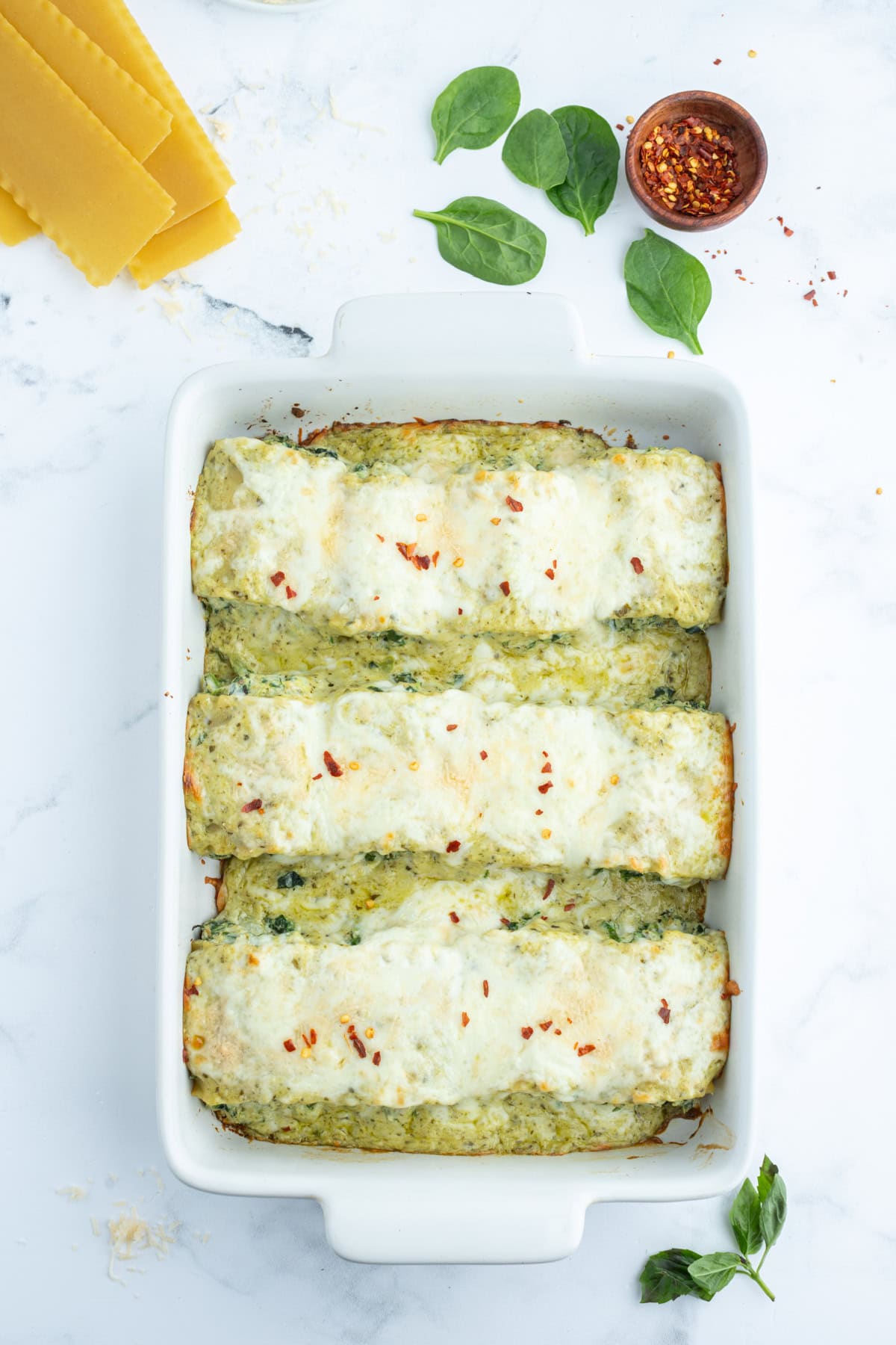 overhead shot of pesto lasagna rolls in casserole dish