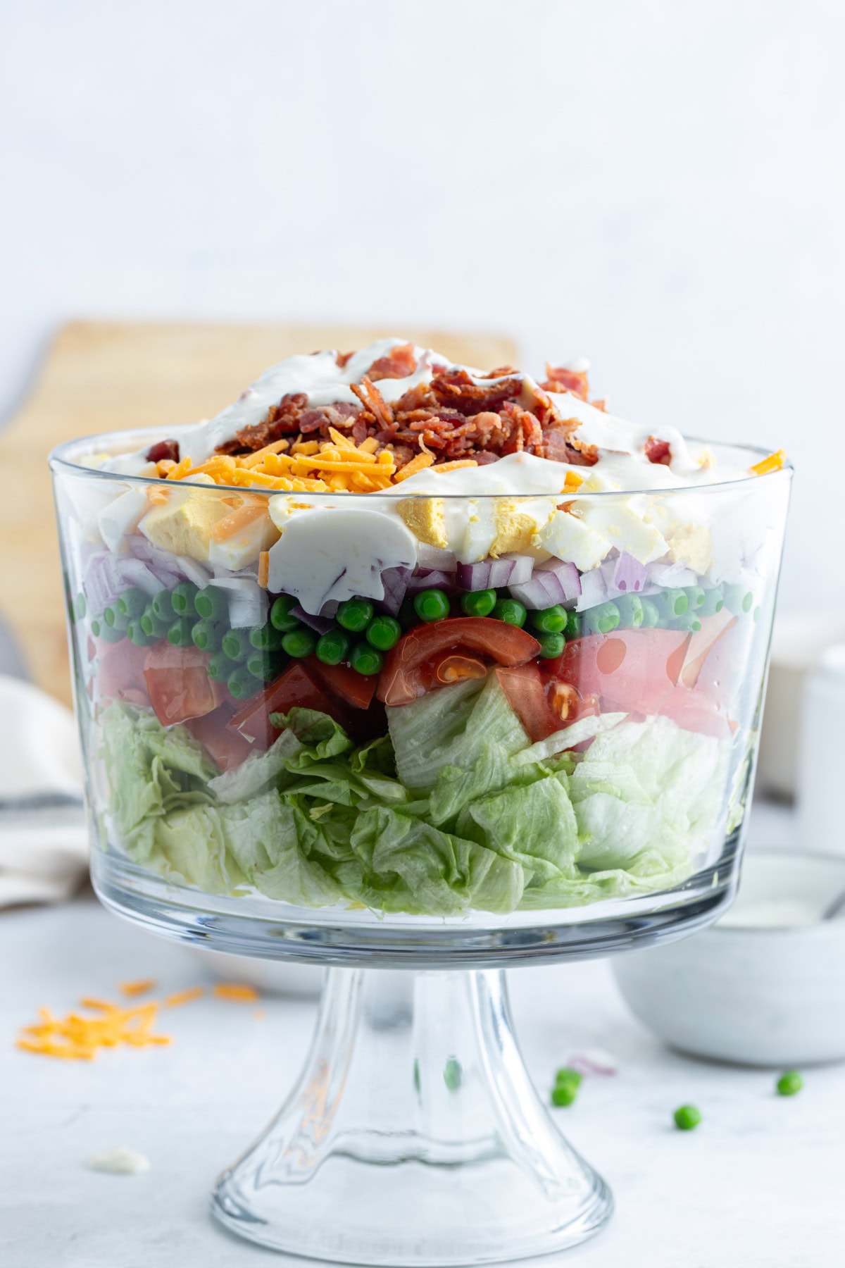 7 layer salad with dressing in trifle bowl