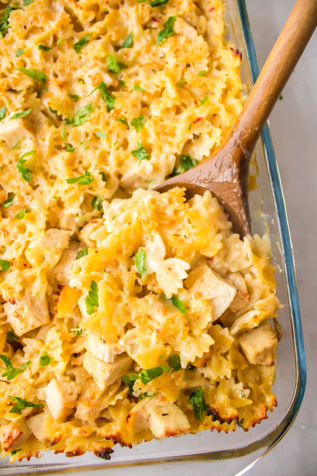 wooden spoon in pan of creamy lemon chicken pasta