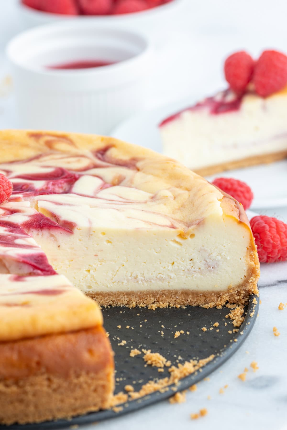 white chocolate raspberry cheescake with large slice taken out